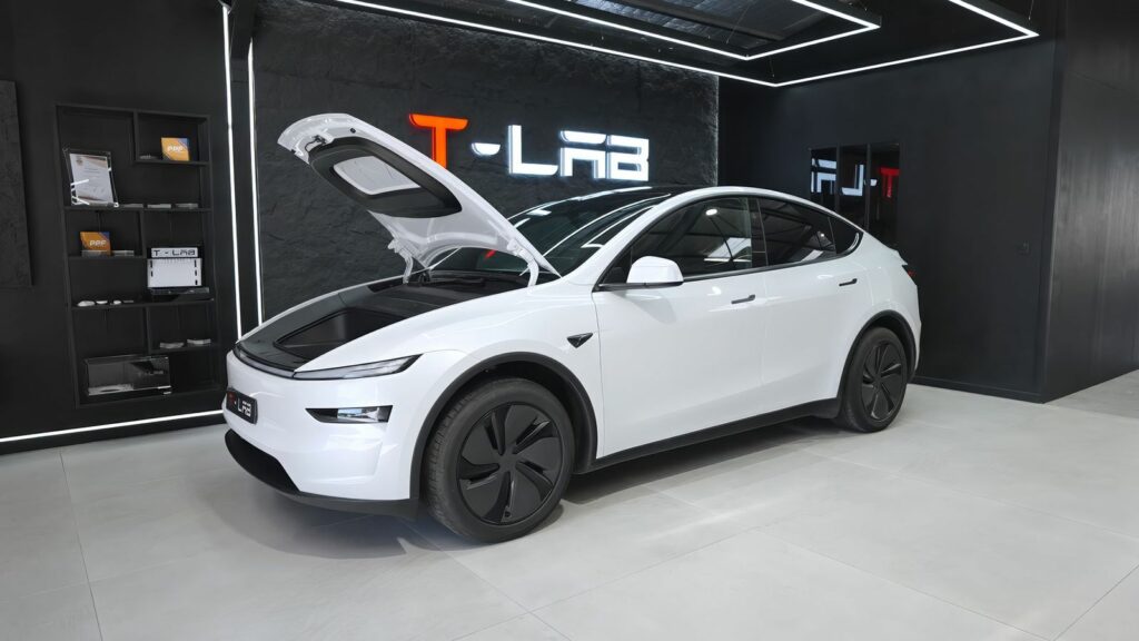 Tesla Model Y blanche, capot avant motorisé ouvert, dans l’atelier T - Lab